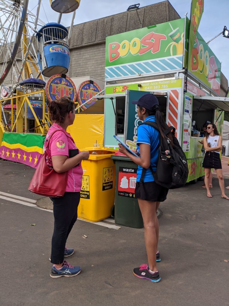 Resource Recovery Officer Priya having a chat about recycling with an engaged festival goer